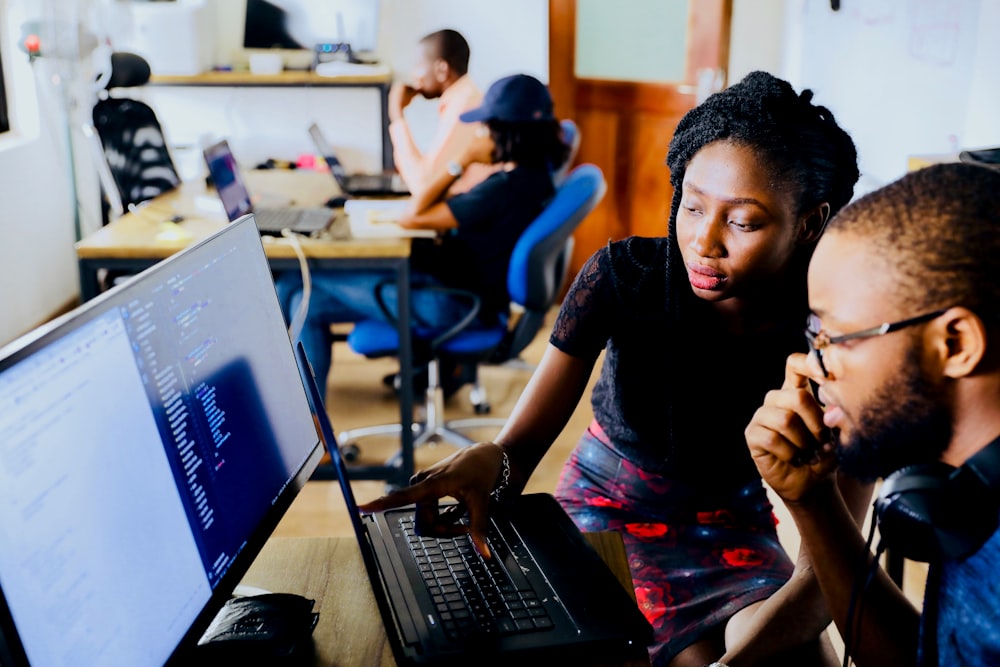 Two people working through a task on a laptop